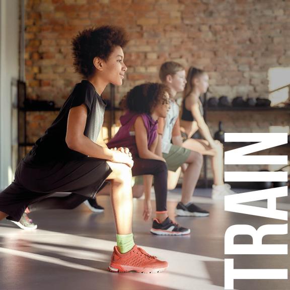 Four children in a line lunging forward with wording 'TRAIN'